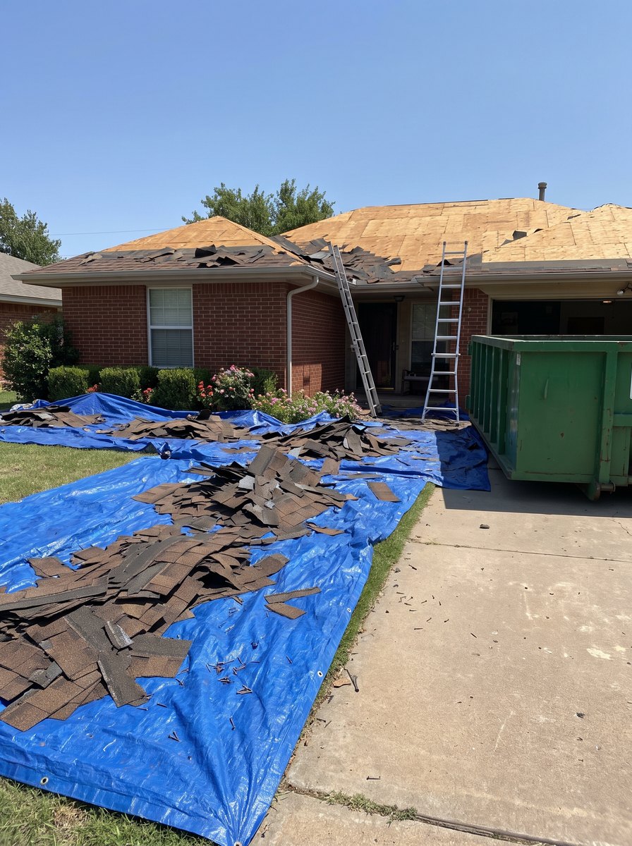 Roof day: tarps over the flower beds and the dumpster in the drive.