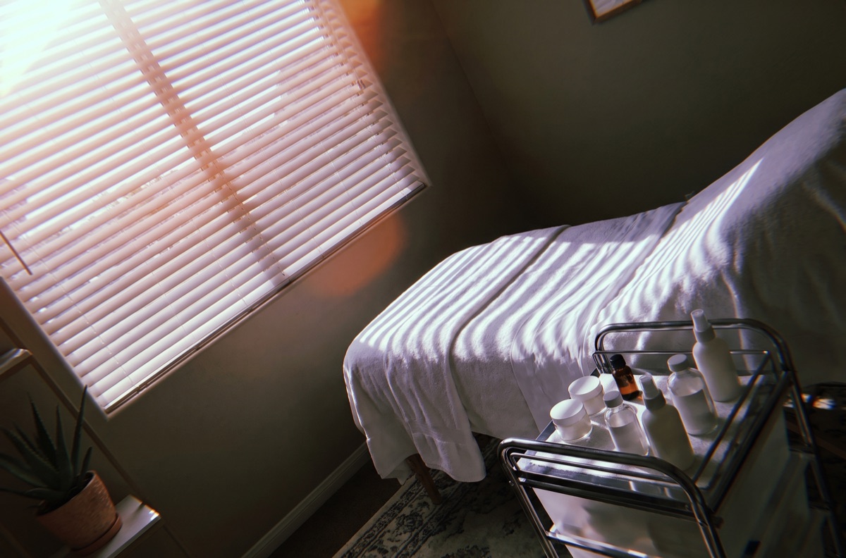 The facial room on a June afternoon, blinds half down against the heat. The owner sent it as the room to feature.