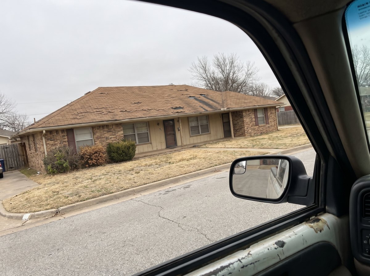 The house at the estimate in March, shot from the truck window.