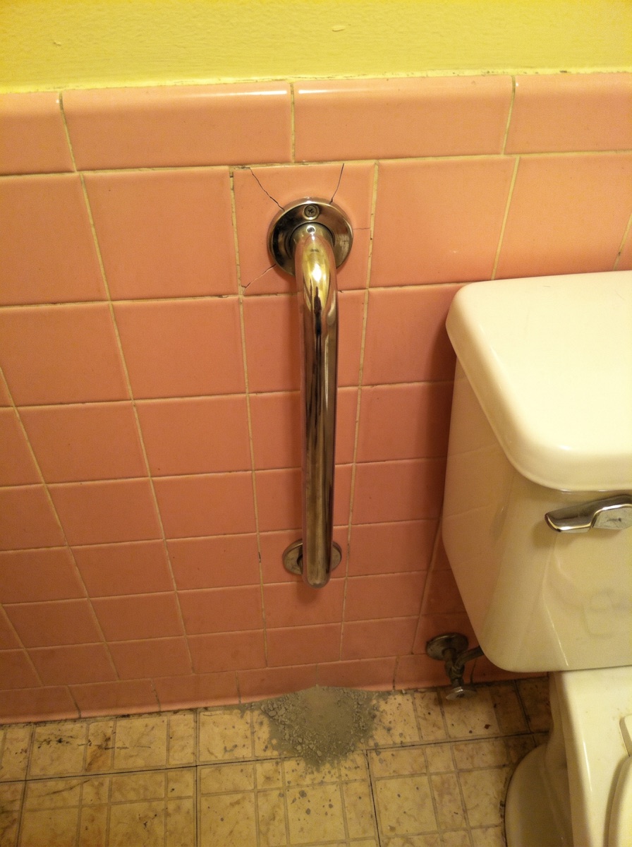 The chrome grab bar a handyman screwed into the tile. It cracked the tile and was the reason they called.