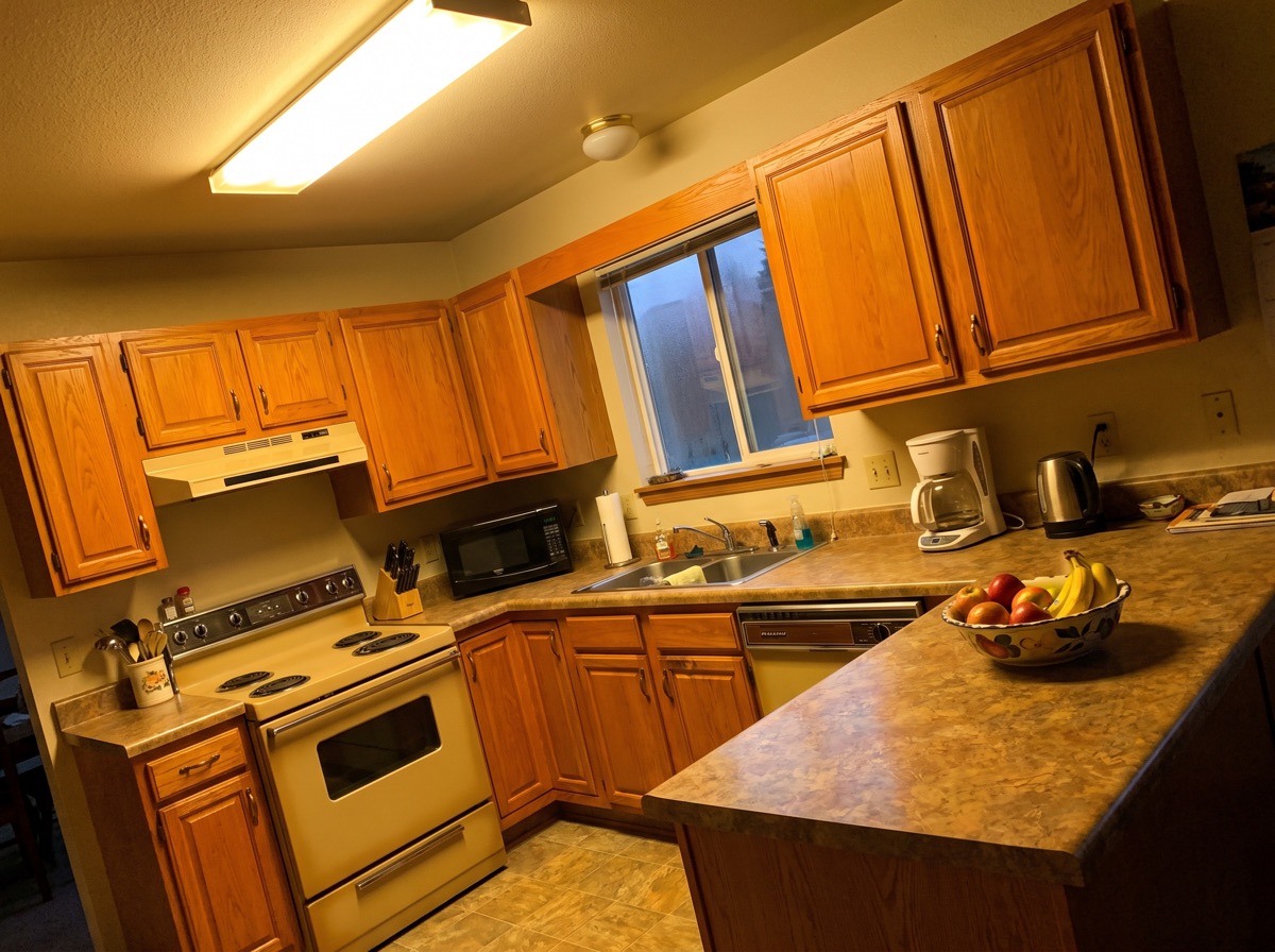 A 1994 oak kitchen in Shrewsbury at the estimate, gone orange after thirty years of finish.